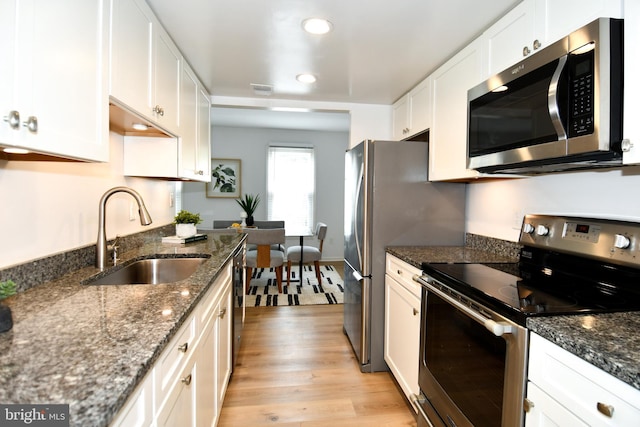 9835 Saint Cloud Ct, Fairfax, VA 22031 - kitchen with appliances with stainless steel finishes, light wood finished floors, white cabinets, recessed lighting, and dark stone counters