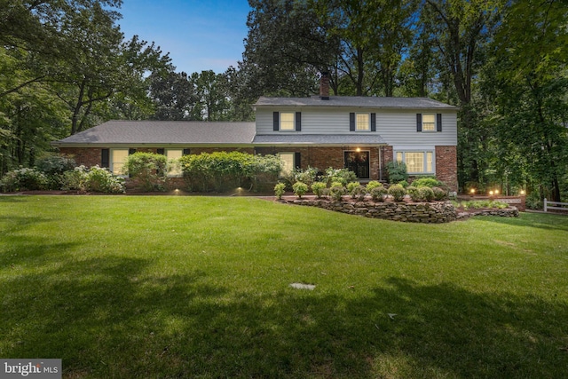 3851 Fawn Ln, White Plains, MD 20695 - traditional-style home with brick siding, a front lawn, and a chimney