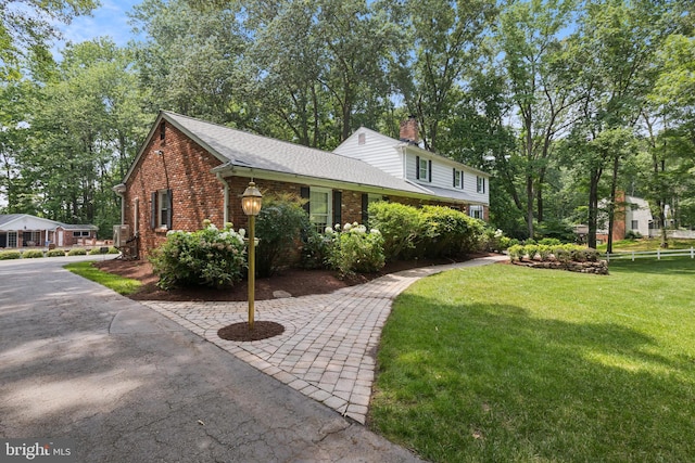3851 Fawn Ln, White Plains, MD 20695 - view of side of home with brick siding, a yard, a chimney, and a shingled roof