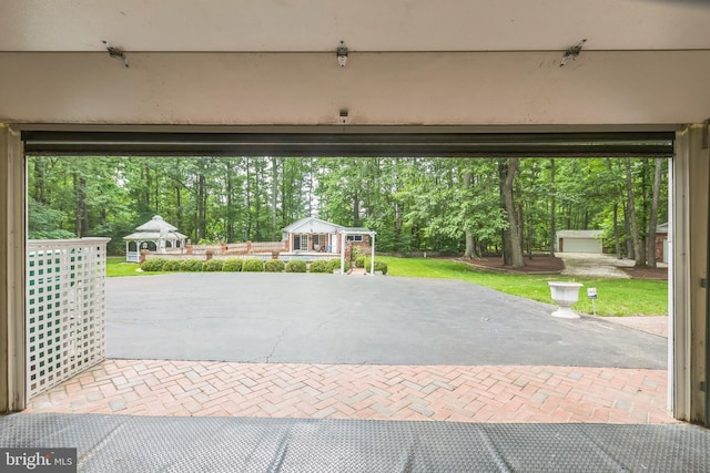 3851 Fawn Ln, White Plains, MD 20695 - garage featuring decorative driveway and view of scattered trees