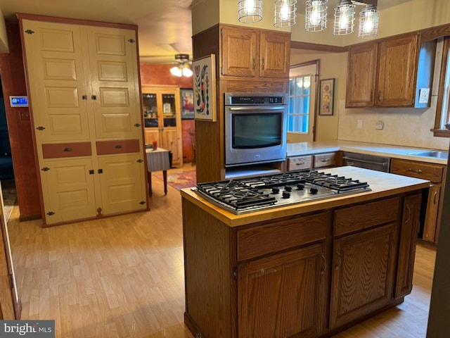 400 27th St, Huntingdon, PA 16652 - kitchen with stainless steel appliances, light wood-type flooring, light countertops, a ceiling fan, and brown cabinetry