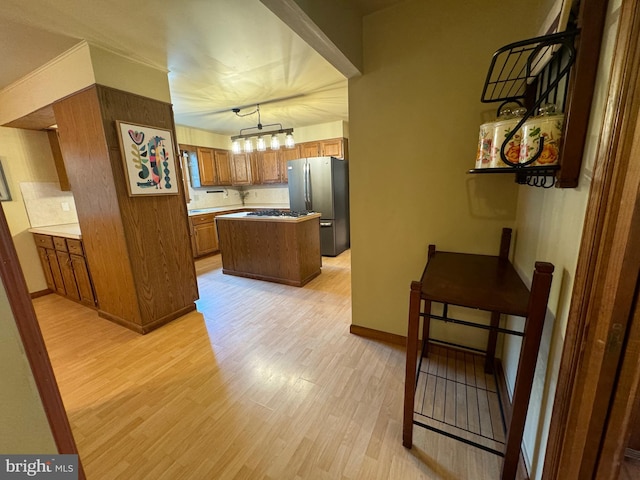 400 27th St, Huntingdon, PA 16652 - kitchen with freestanding refrigerator, light wood-type flooring, brown cabinets, and a center island