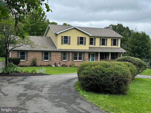 400 27th St, Huntingdon, PA 16652 - traditional home featuring brick siding, a front lawn, a shingled roof, and a chimney