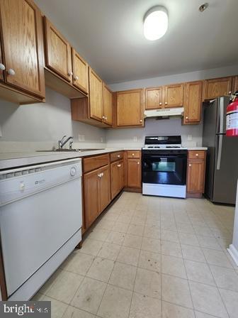 337 Nicholas Dr, Riverside, NJ 08075 - kitchen with white appliances, under cabinet range hood, light countertops, and brown cabinetry
