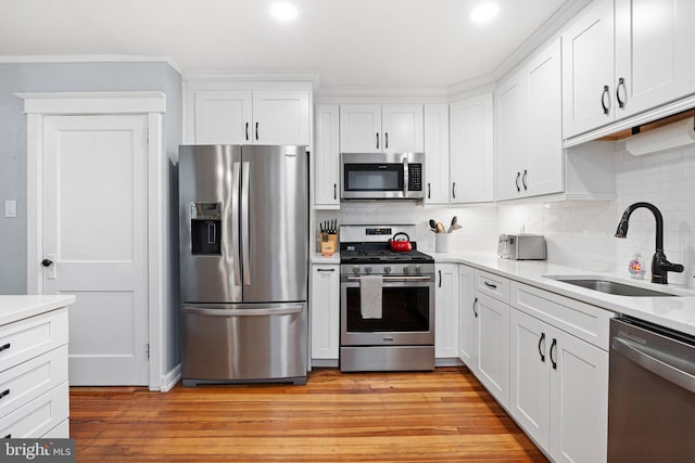 1123 Maple St, Conshohocken, PA 19428 - kitchen featuring appliances with stainless steel finishes, decorative backsplash, white cabinetry, light countertops, and light wood-style floors