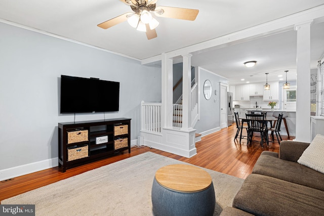 1123 Maple St, Conshohocken, PA 19428 - living room featuring stairs, light wood-style floors, ornamental molding, and ceiling fan