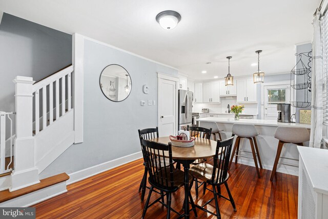 1123 Maple St, Conshohocken, PA 19428 - dining room featuring dark wood-type flooring, stairs, recessed lighting, and ornamental molding