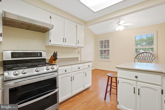13 Gelding Ct, Olney, MD 20832 - kitchen featuring range with two ovens, exhaust hood, light wood-style floors, white cabinetry, and vaulted ceiling