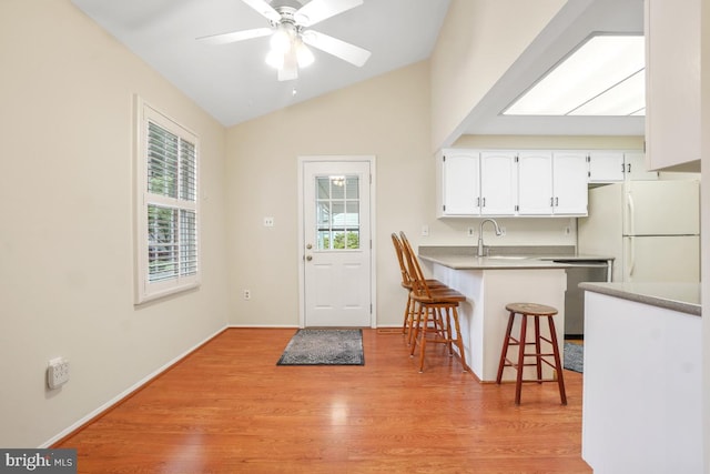 13 Gelding Ct, Olney, MD 20832 - kitchen with freestanding refrigerator, a breakfast bar, white cabinets, lofted ceiling, and light wood-style flooring