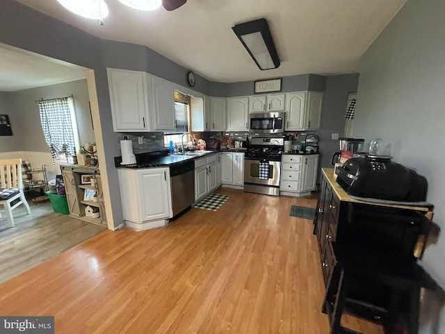 1105 Darlington Rd, Beaver Falls, PA 15010 - kitchen featuring stainless steel appliances, dark countertops, light wood-style floors, white cabinetry, and decorative backsplash