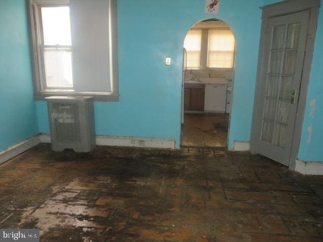 5505 Loretto Ave, Philadelphia, PA 19124 - spare room with arched walkways and radiator heating unit