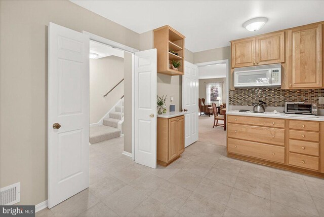 7504 Westlake Ter Unit 25, Bethesda, MD 20817 - kitchen with white appliances, open shelves, light countertops, tasteful backsplash, and light brown cabinets