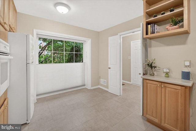 7504 Westlake Ter Unit 25, Bethesda, MD 20817 - kitchen featuring white appliances, light countertops, open shelves, and light brown cabinetry