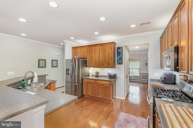 1404 Preserve Ln, Fredericksburg, VA 22401 - kitchen with appliances with stainless steel finishes, light wood-type flooring, crown molding, recessed lighting, and brown cabinetry