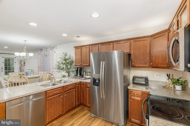 1404 Preserve Ln, Fredericksburg, VA 22401 - kitchen featuring appliances with stainless steel finishes, a chandelier, light wood-type flooring, brown cabinetry, and recessed lighting