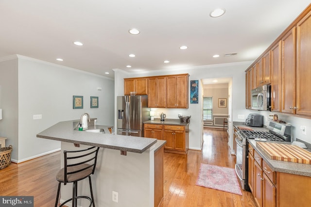 1404 Preserve Ln, Fredericksburg, VA 22401 - kitchen with stainless steel appliances, a breakfast bar, recessed lighting, light wood finished floors, and crown molding