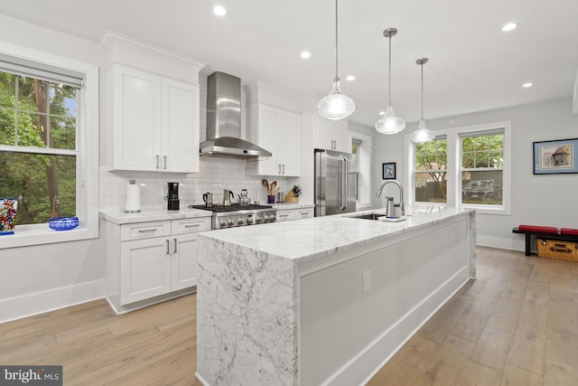 2819 Bellevue Ter NW, Washington, DC 20007 - kitchen with wall chimney exhaust hood, appliances with stainless steel finishes, white cabinetry, light wood-style floors, and recessed lighting