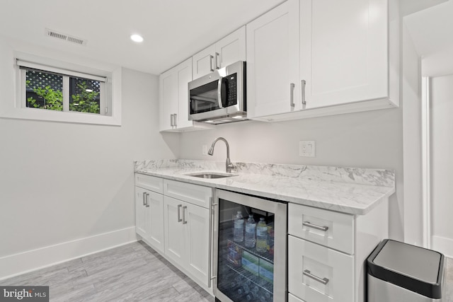 2819 Bellevue Ter NW, Washington, DC 20007 - bar featuring wine cooler, stainless steel microwave, recessed lighting, and light wood finished floors