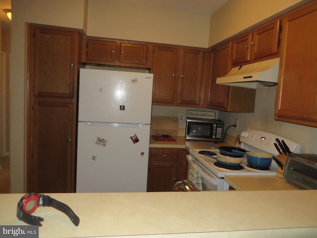 6915 Victoria Dr Unit C, Alexandria, VA 22310 - kitchen with white appliances, under cabinet range hood, light countertops, and brown cabinets