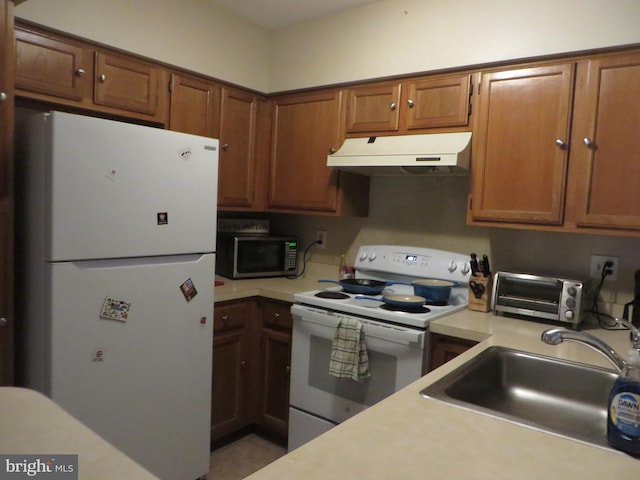6915 Victoria Dr Unit C, Alexandria, VA 22310 - kitchen with white appliances, under cabinet range hood, light countertops, and brown cabinetry