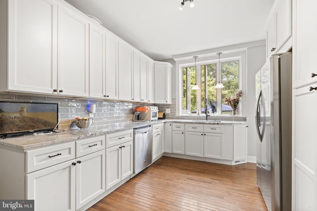33 Waverly Rd, Wyncote, PA 19095 - kitchen with stainless steel appliances, light wood finished floors, white cabinetry, decorative backsplash, and light stone countertops