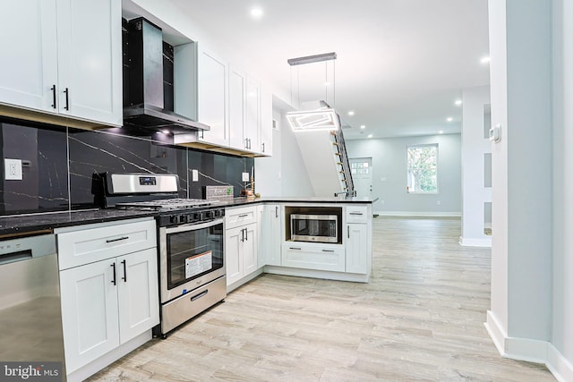 3321 N 11th St, Philadelphia, PA 19140 - kitchen with appliances with stainless steel finishes, wall chimney exhaust hood, a peninsula, light wood-style floors, and decorative backsplash