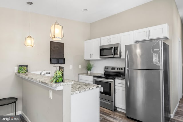 1001 S Carey St, Baltimore, MD 21223 - kitchen featuring appliances with stainless steel finishes, white cabinets, dark wood-type flooring, a peninsula, and hanging light fixtures
