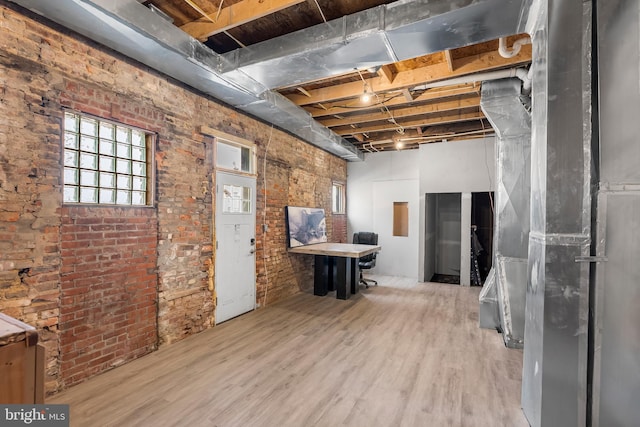 1001 S Carey St, Baltimore, MD 21223 - basement with wood finished floors, brick wall, and heating unit