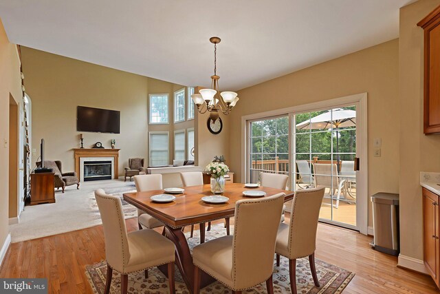 13 Buckwalter Cir, Royersford, PA 19468 - dining area with healthy amount of natural light, a chandelier, a glass covered fireplace, and light wood-style floors