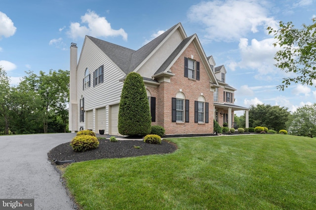 13 Buckwalter Cir, Royersford, PA 19468 - view of home's exterior featuring an attached garage, a chimney, brick siding, a lawn, and driveway