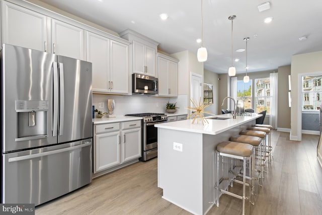 6049 Beake St, Hyattsville, MD 20782 - kitchen with stainless steel appliances, light wood finished floors, an island with sink, light countertops, and recessed lighting