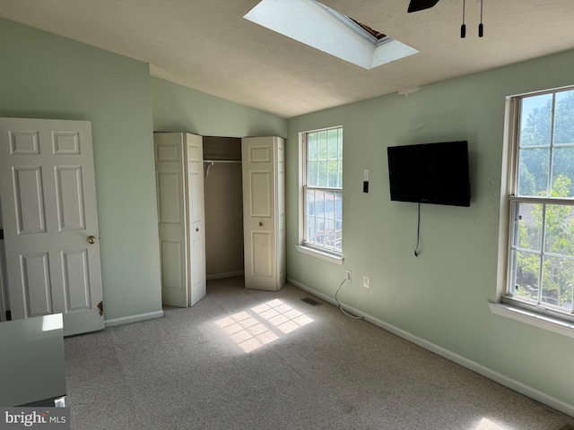 8902 Chesapeake Lighthouse Dr, North Beach, MD 20714 - unfurnished bedroom with a skylight, light carpet, multiple windows, and vaulted ceiling