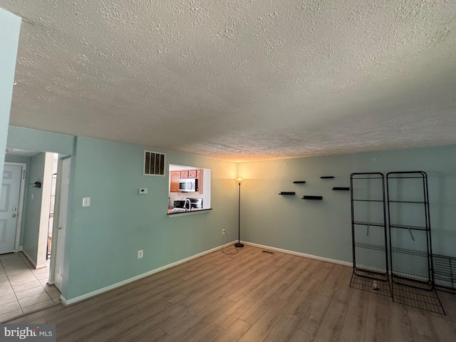 8902 Chesapeake Lighthouse Dr, North Beach, MD 20714 - unfurnished room with a textured ceiling and wood finished floors