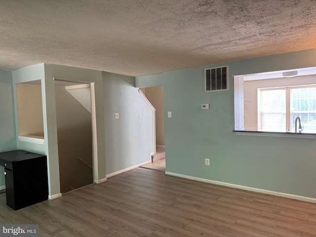 8902 Chesapeake Lighthouse Dr, North Beach, MD 20714 - unfurnished room featuring a textured ceiling and wood finished floors