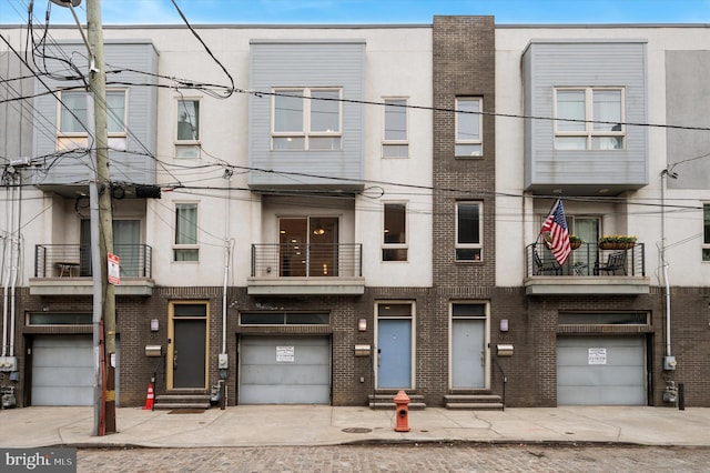 914 N Front St, Philadelphia, PA 19123 - view of property with entry steps, an attached garage, and brick siding
