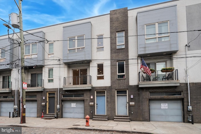 914 N Front St, Philadelphia, PA 19123 - view of property featuring entry steps, brick siding, and a garage