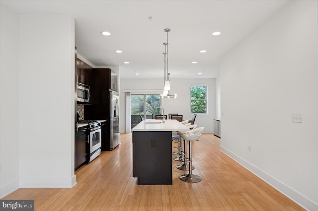 914 N Front St, Philadelphia, PA 19123 - kitchen with stainless steel appliances, a breakfast bar area, a center island with sink, light countertops, and recessed lighting