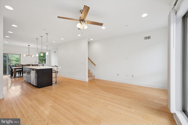 914 N Front St, Philadelphia, PA 19123 - kitchen with a breakfast bar area, stainless steel dishwasher, an island with sink, light wood-style flooring, and light countertops