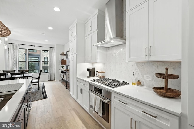 3536 Sutton Heights Cir, Fairfax, VA 22031 - kitchen featuring wall chimney range hood, stainless steel appliances, light wood-style floors, recessed lighting, and white cabinets