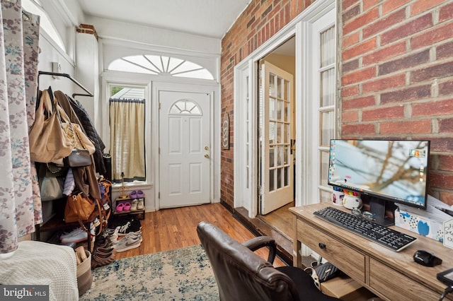 1128 Wilson Dr, Havertown, PA 19083 - foyer entrance with brick wall and wood finished floors