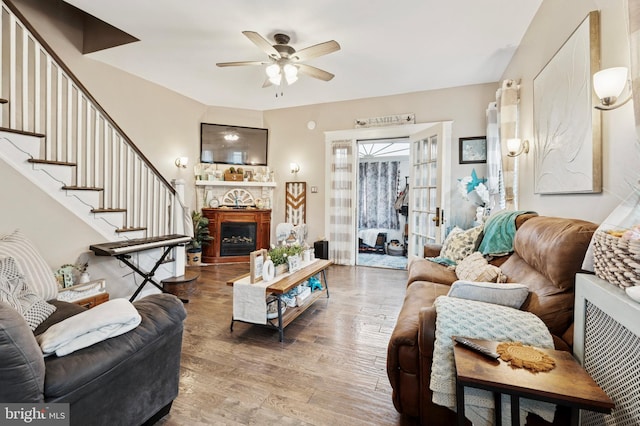 1128 Wilson Dr, Havertown, PA 19083 - living room with wood finished floors, ceiling fan, a fireplace, radiator heating unit, and stairway