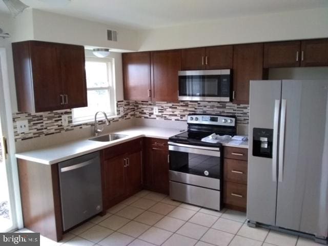 117 Clemens Ct, Lansdale, PA 19446 - kitchen featuring appliances with stainless steel finishes, light countertops, decorative backsplash, light tile patterned floors, and dark brown cabinets