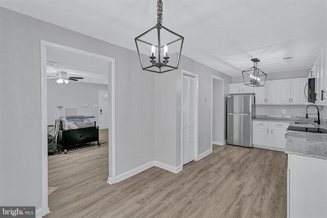 18721 Paprika Ct, Germantown, MD 20874 - kitchen featuring appliances with stainless steel finishes, a chandelier, white cabinets, and light wood finished floors