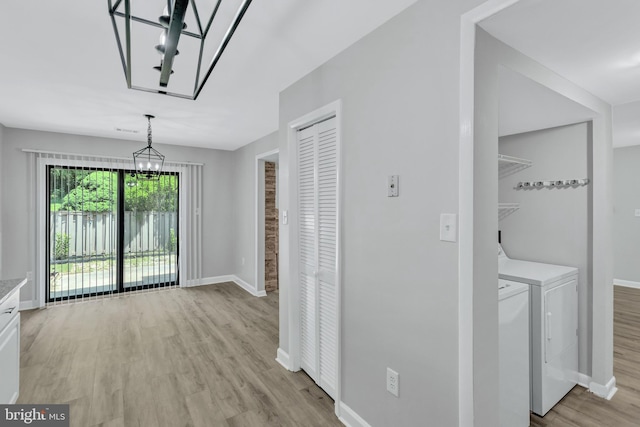 18721 Paprika Ct, Germantown, MD 20874 - unfurnished dining area with washing machine and dryer, a chandelier, and light wood-style floors