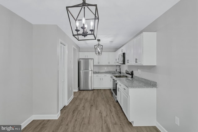 18721 Paprika Ct, Germantown, MD 20874 - kitchen featuring appliances with stainless steel finishes, a chandelier, light wood-style flooring, white cabinets, and decorative light fixtures