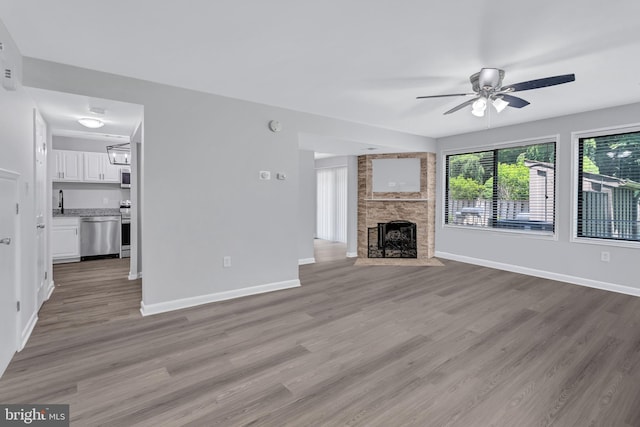 18721 Paprika Ct, Germantown, MD 20874 - unfurnished living room featuring a ceiling fan, wood finished floors, and a large fireplace