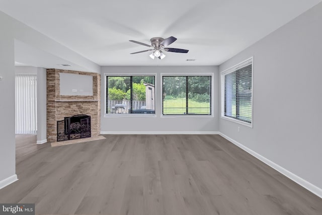 18721 Paprika Ct, Germantown, MD 20874 - unfurnished living room with wood finished floors, a ceiling fan, and a stone fireplace