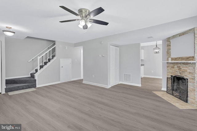 18721 Paprika Ct, Germantown, MD 20874 - unfurnished living room with stairs, wood finished floors, ceiling fan, and a fireplace