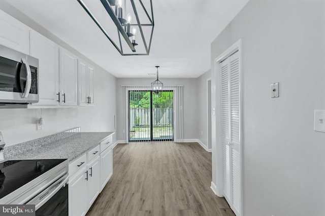 18721 Paprika Ct, Germantown, MD 20874 - kitchen with electric range, stainless steel microwave, a chandelier, and white cabinetry