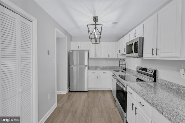 18721 Paprika Ct, Germantown, MD 20874 - kitchen with stainless steel appliances, light wood-type flooring, and white cabinets